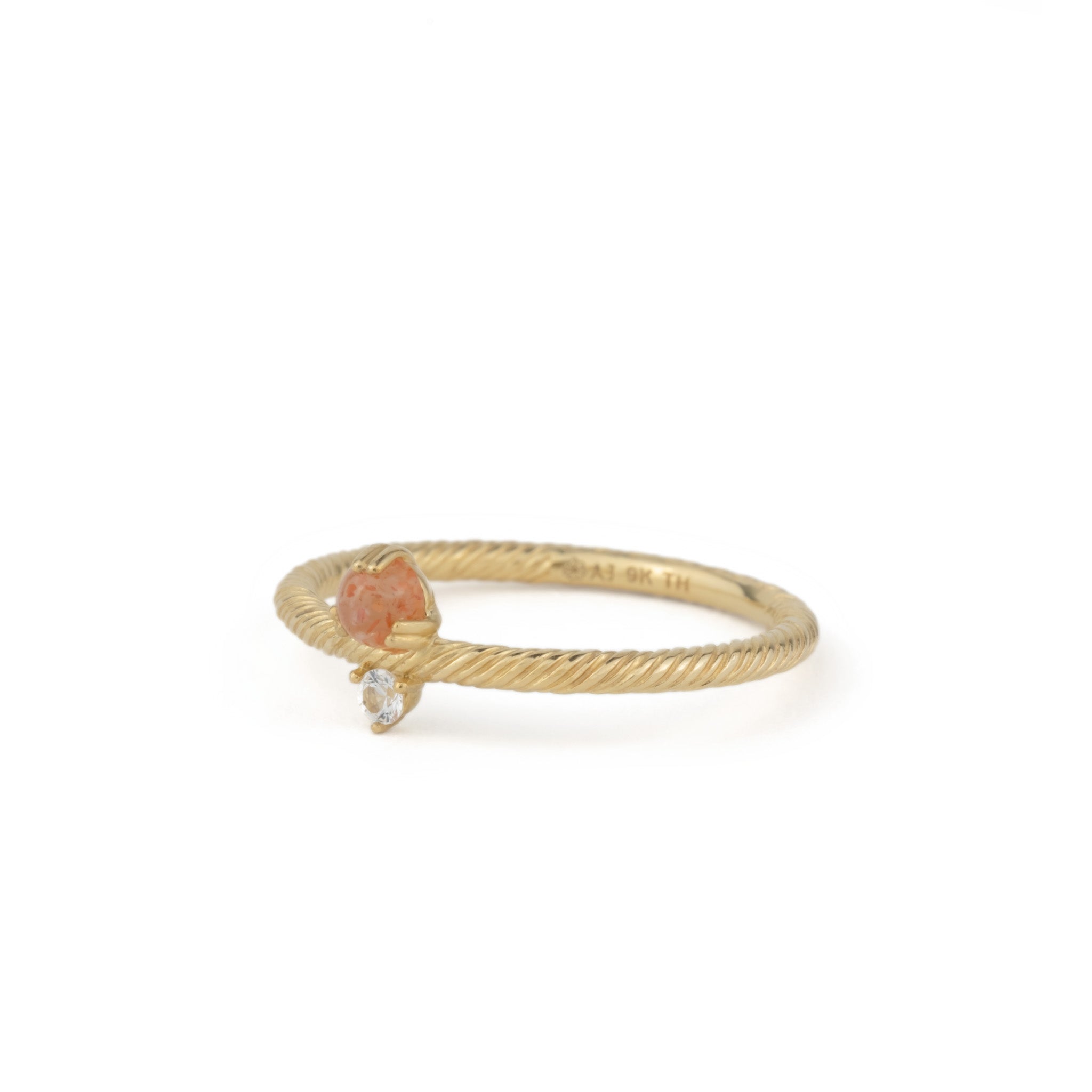 Angled view of solid gold ring with twisted texture, sunstone, white sapphire, and minimalist design, on white background.