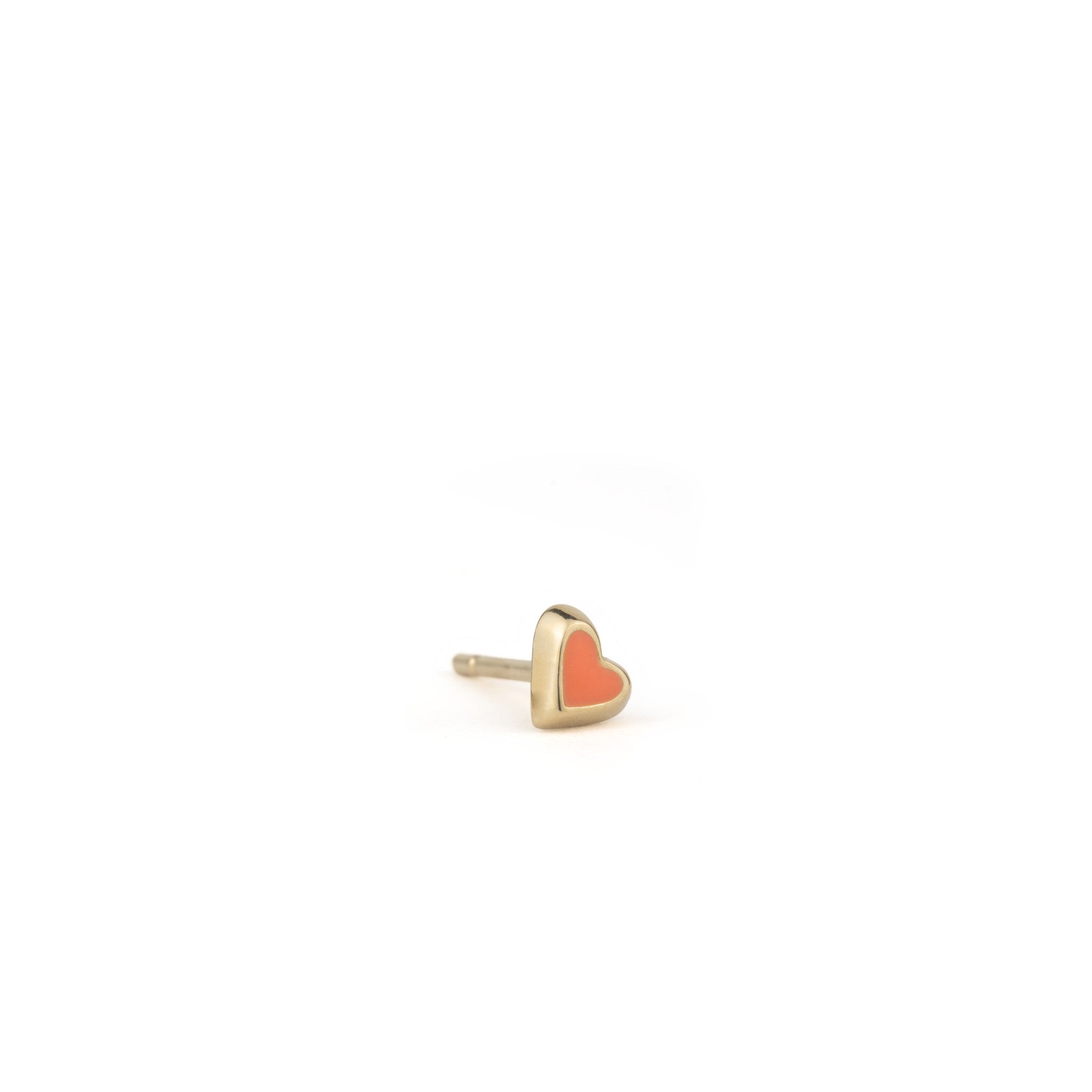 Angled view of solid gold tiny heart stud earring with coral enamel, displayed on white background.