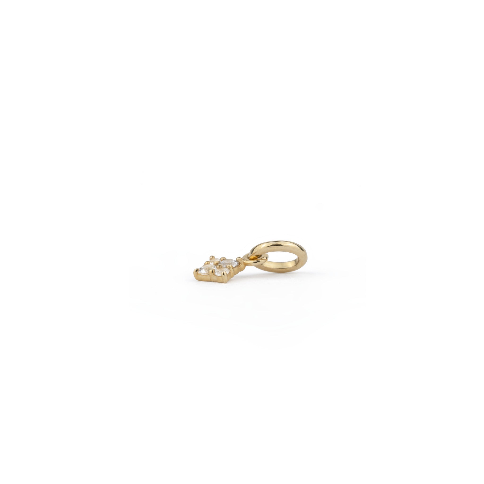Side view of solid gold tiny charm pendant with white sapphire, in a minimalist celestial design, shown on white background.