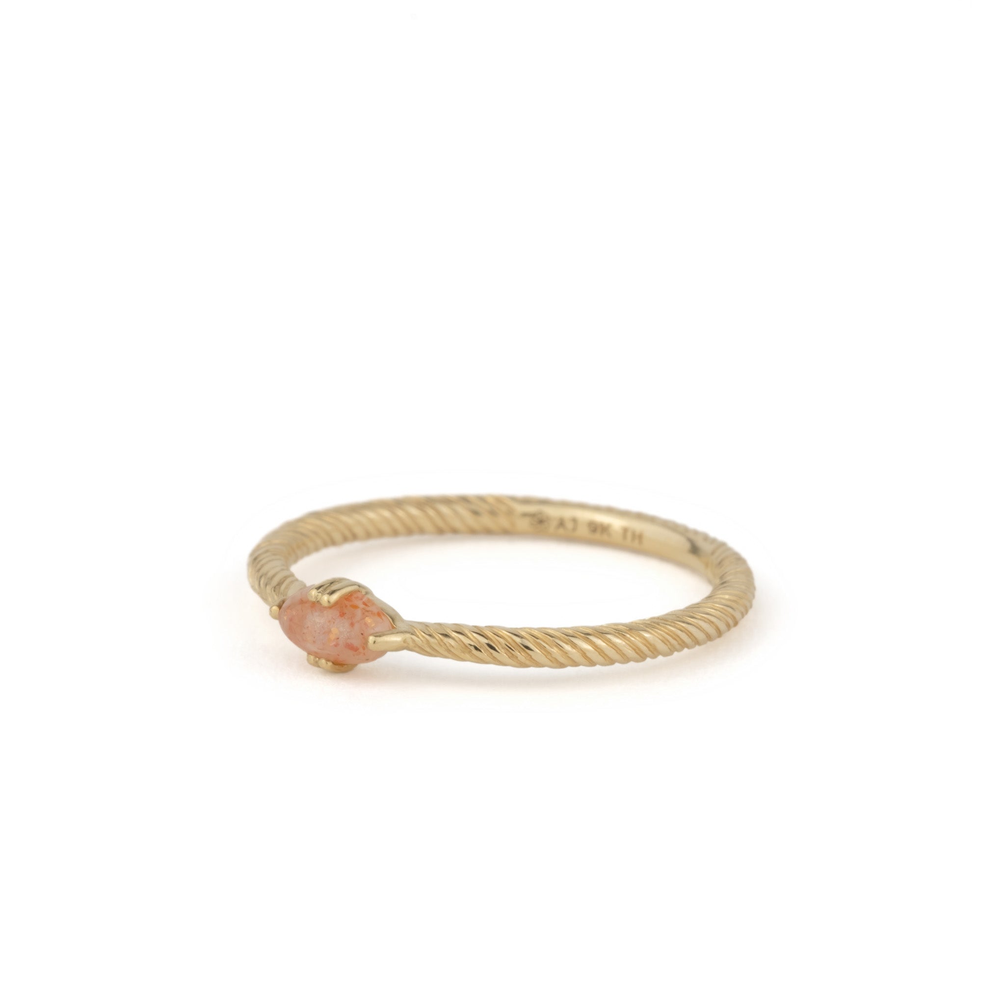 Solid gold solitaire ring with twisted texture, oval cabochon sunstone, and minimalist design, angled on white background.