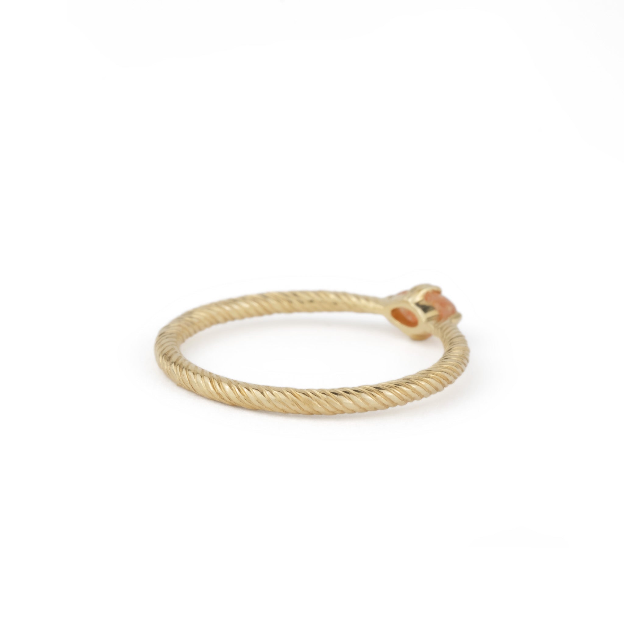 Bottom view of minimalist solid gold solitaire ring with twisted texture and oval cabochon sunstone, on white background.