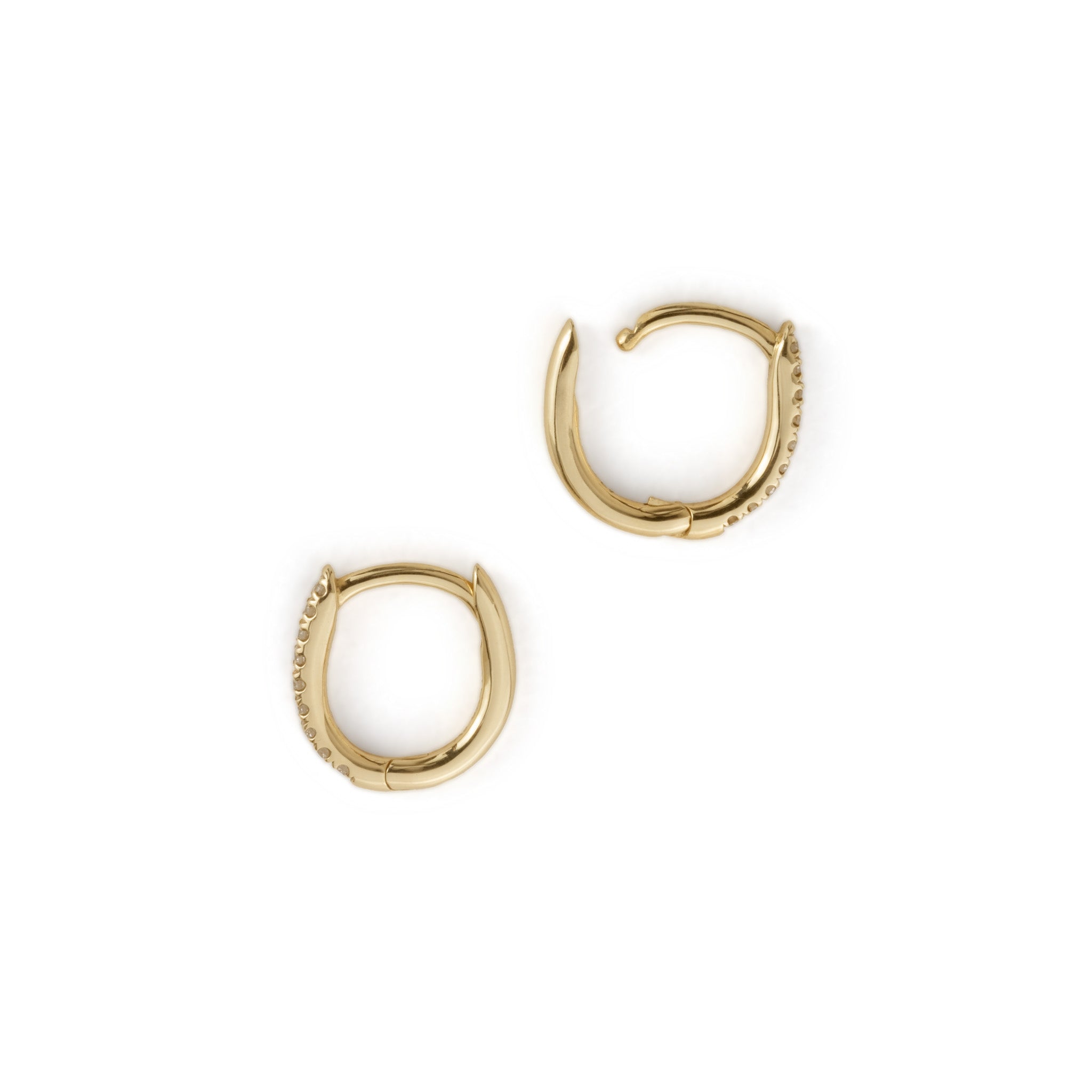Solid gold huggie hoop earrings with split-prong set diamonds, in a minimalist design, flatlay on white background.