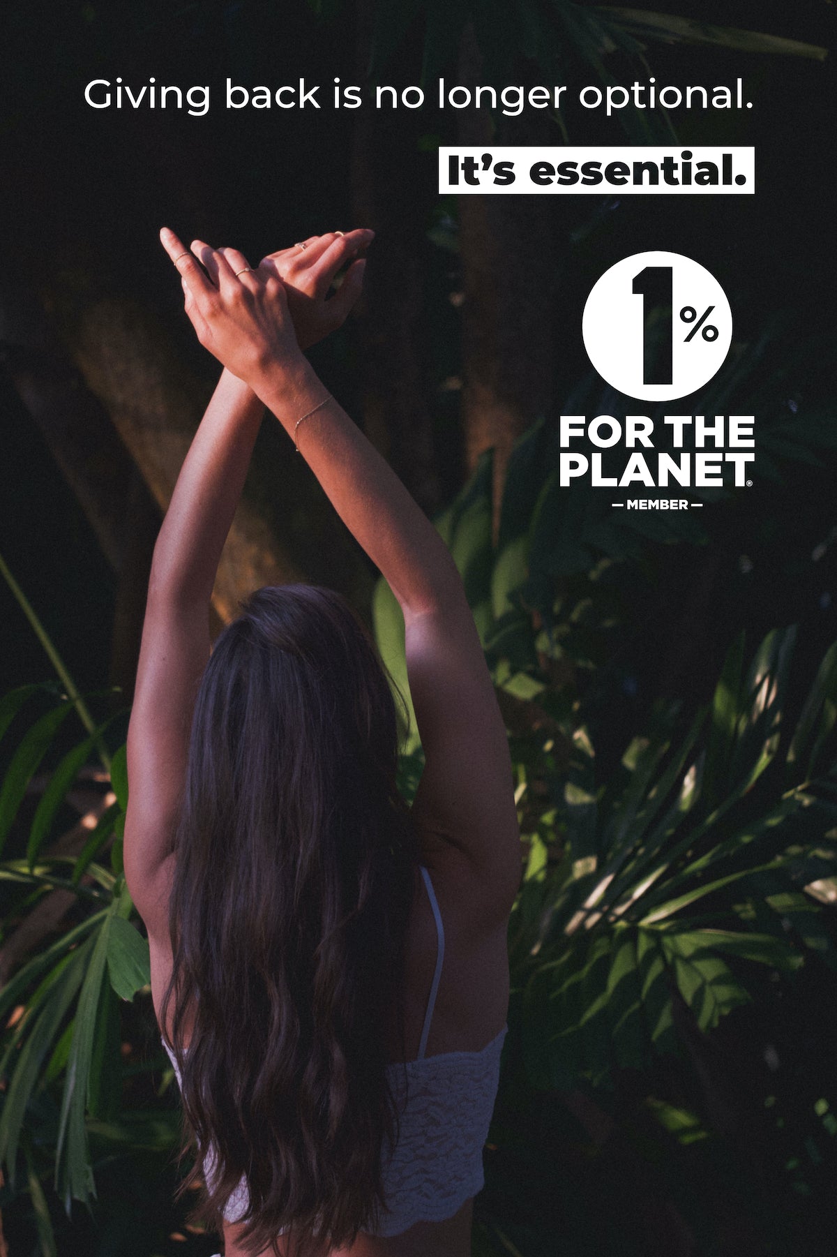 Model with arms stretched upward toward text stating "Giving back is no longer optional. It's essential." 1% for the Planet member logo. Tropical foliage in background.