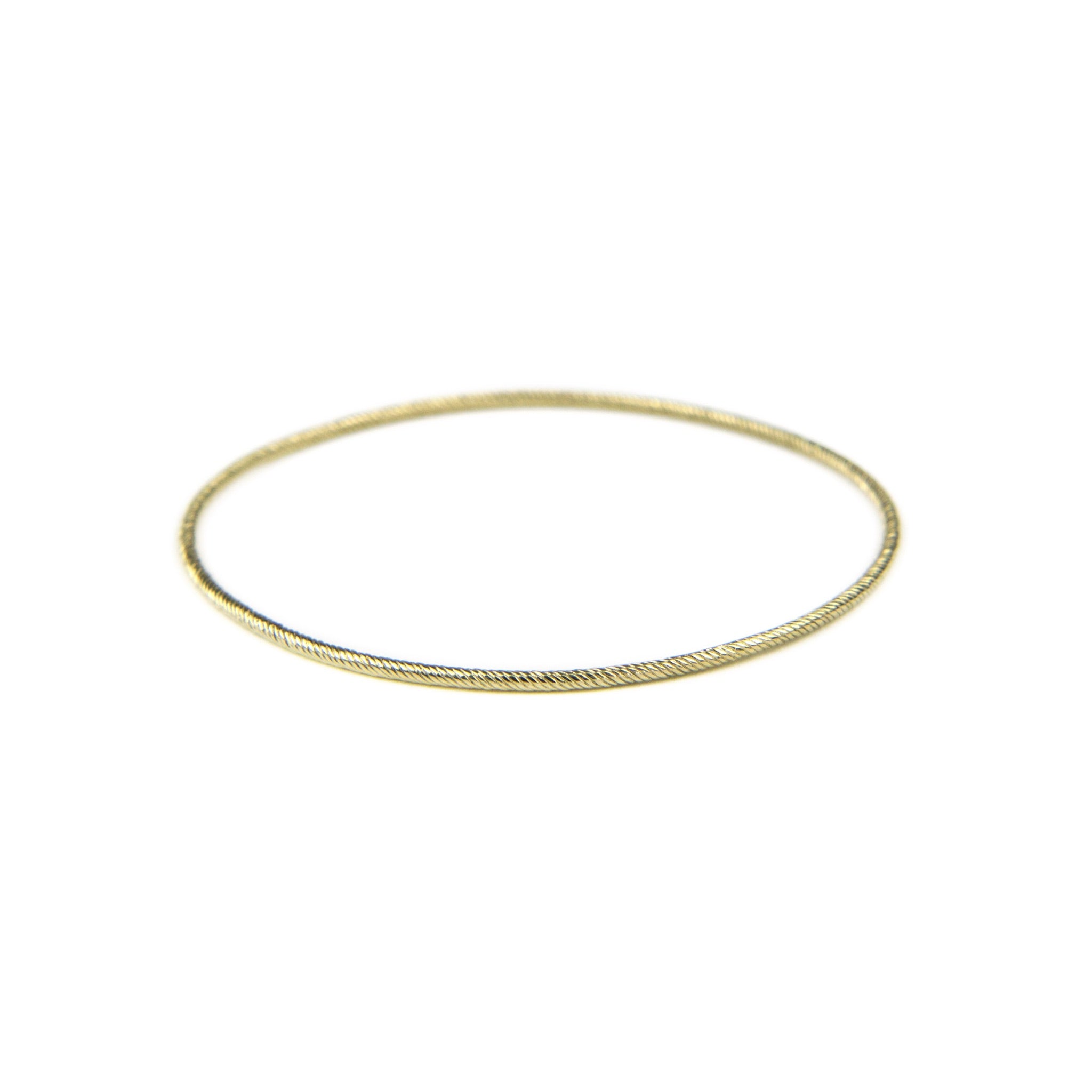 Solid gold thin bangle bracelet with twisted texture and minimalist design, displayed on white background.