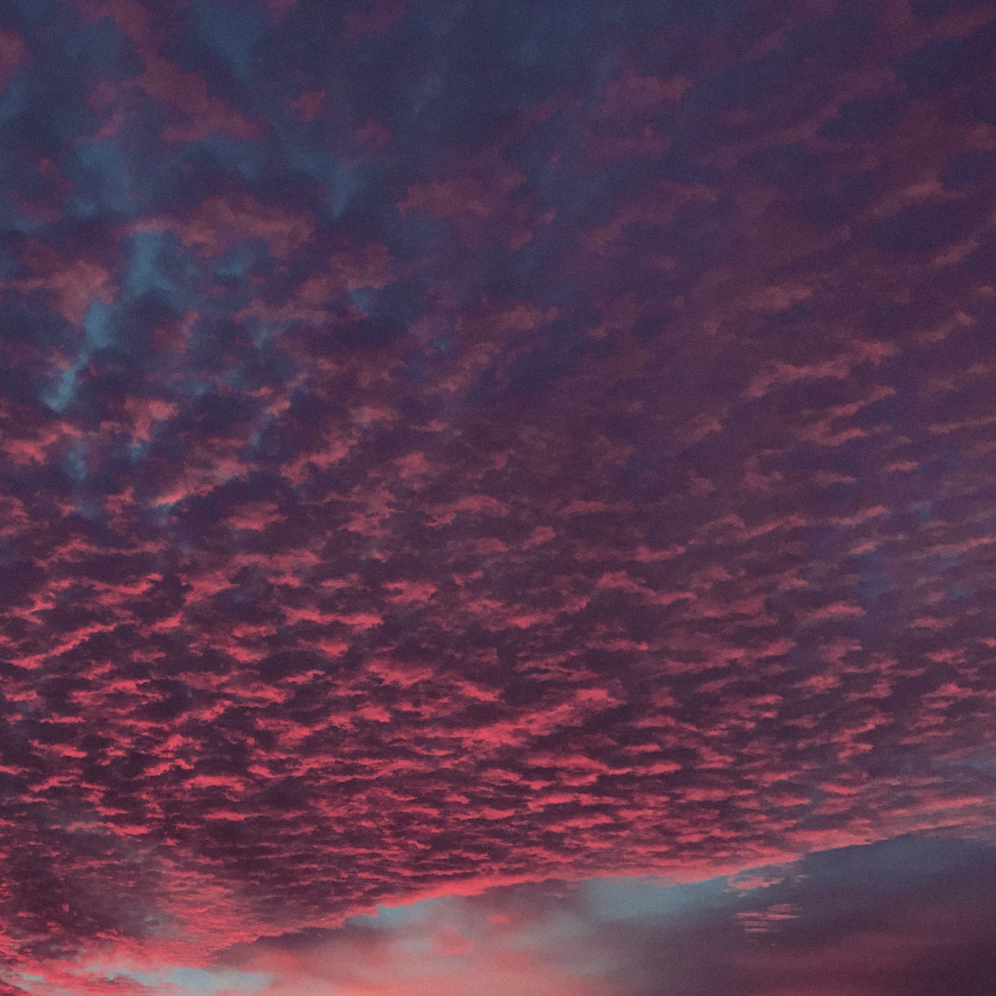 A moody, cloudy sunset sky fading into dusk, glowing with blue, violet, grey, and pink, natural color inspiration.