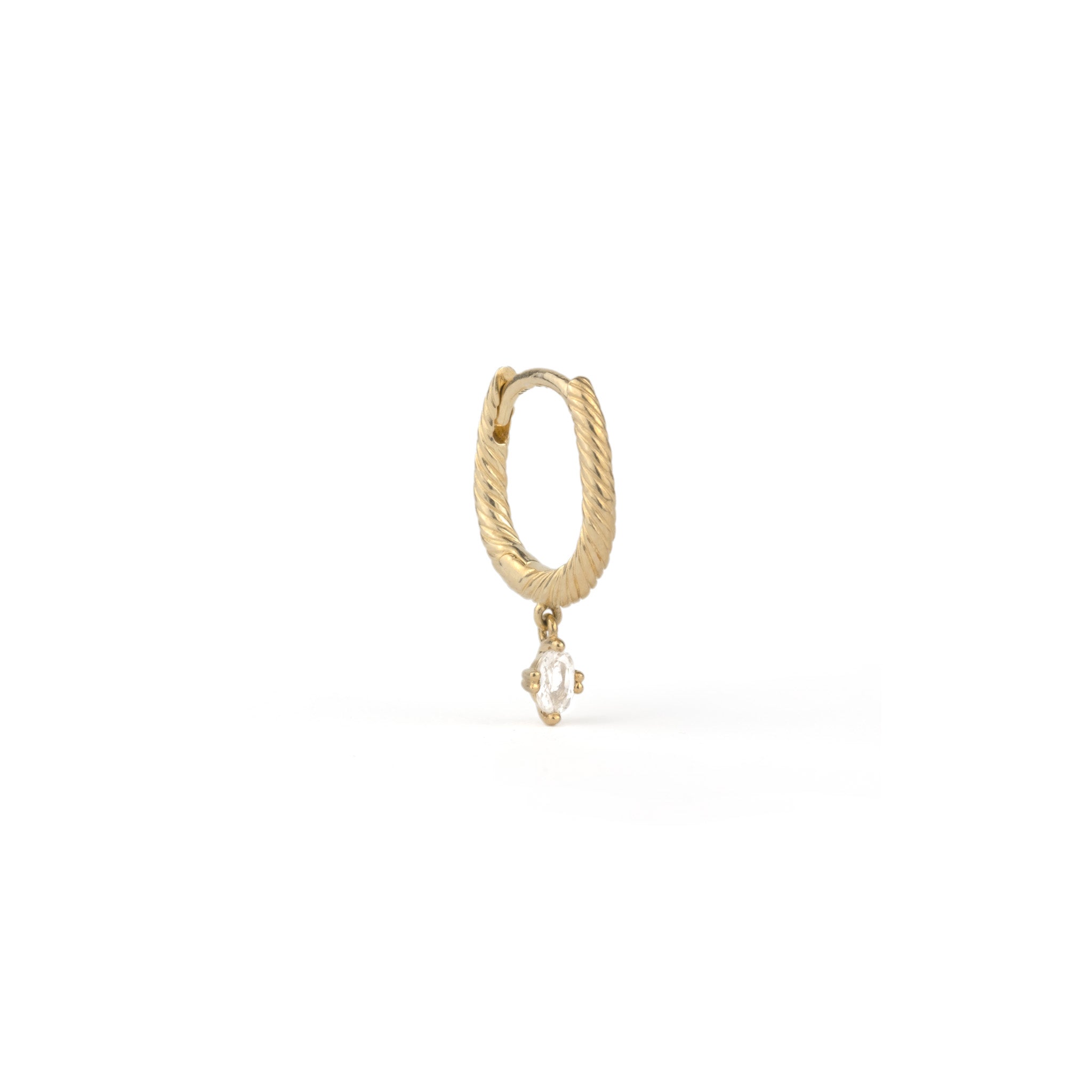 Angled view of solid gold huggie hoop earring with twisted texture and dangling oval white sapphire, on white background.