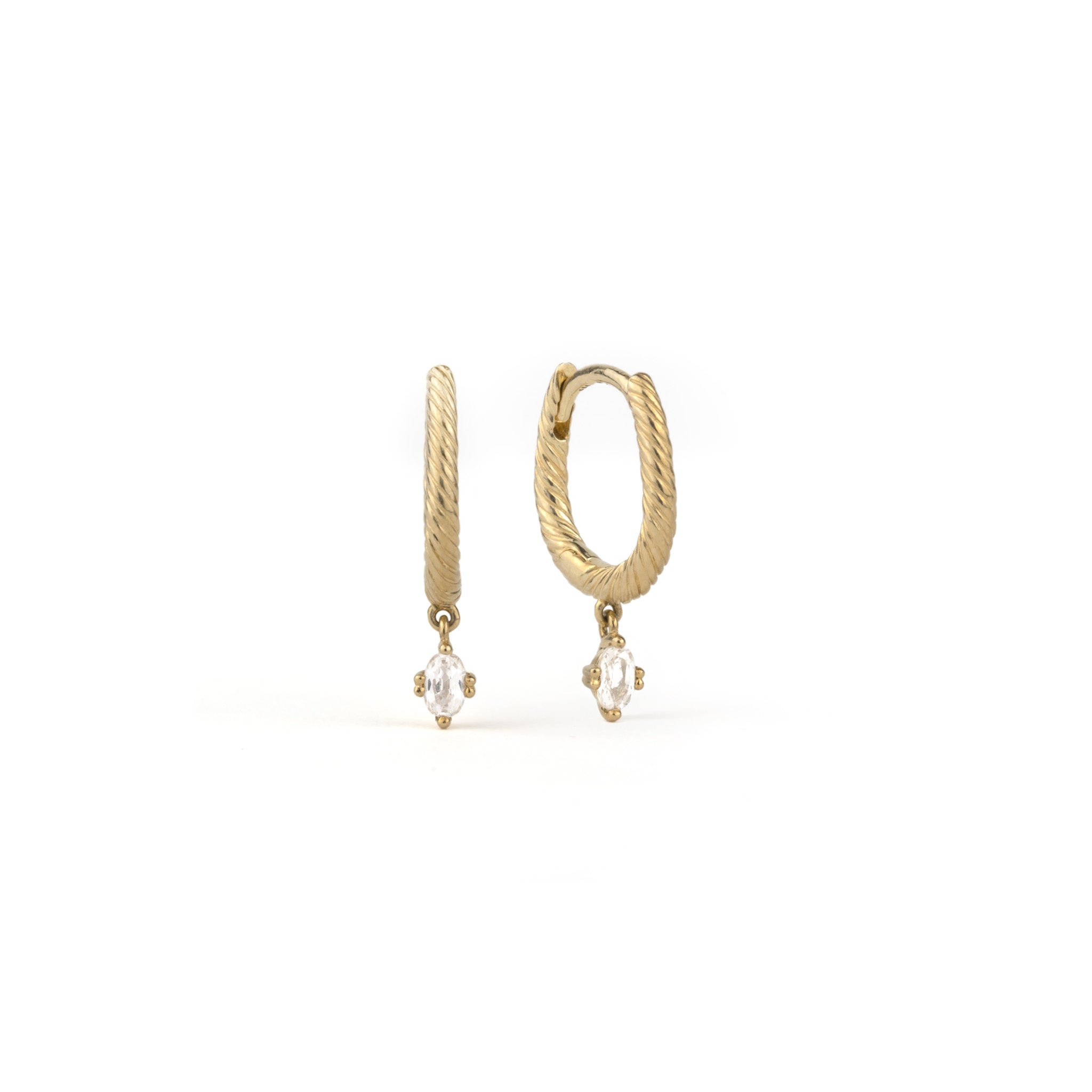 Minimalist solid gold huggie hoop earrings with twisted texture and dangling oval white sapphires, on white background.