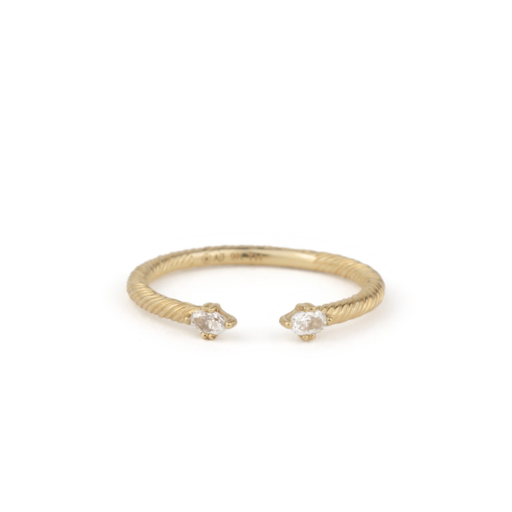 Minimalist solid gold stackable open ring with twisted texture and oval white sapphires on ends, shown on white background.