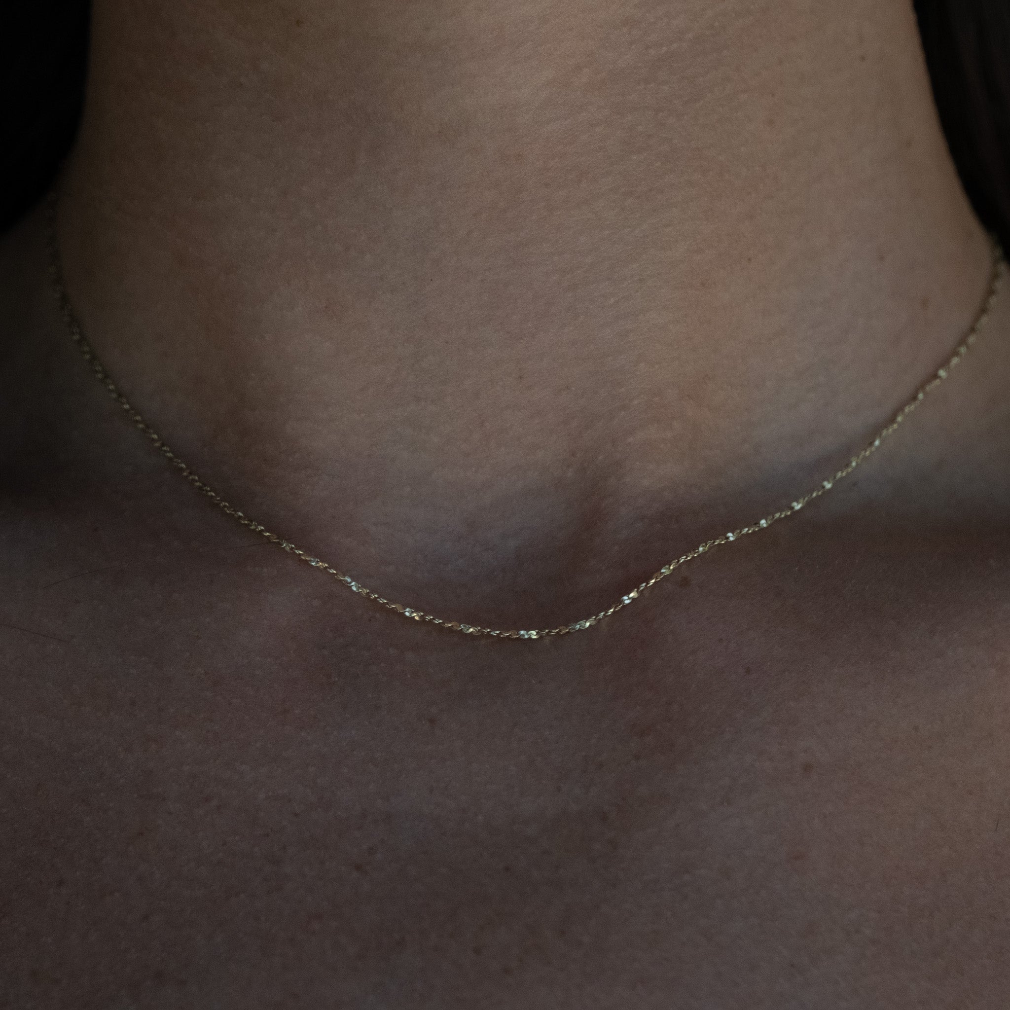 A close up of a person wearing the Aiden Jae Starshine Chain Necklace.