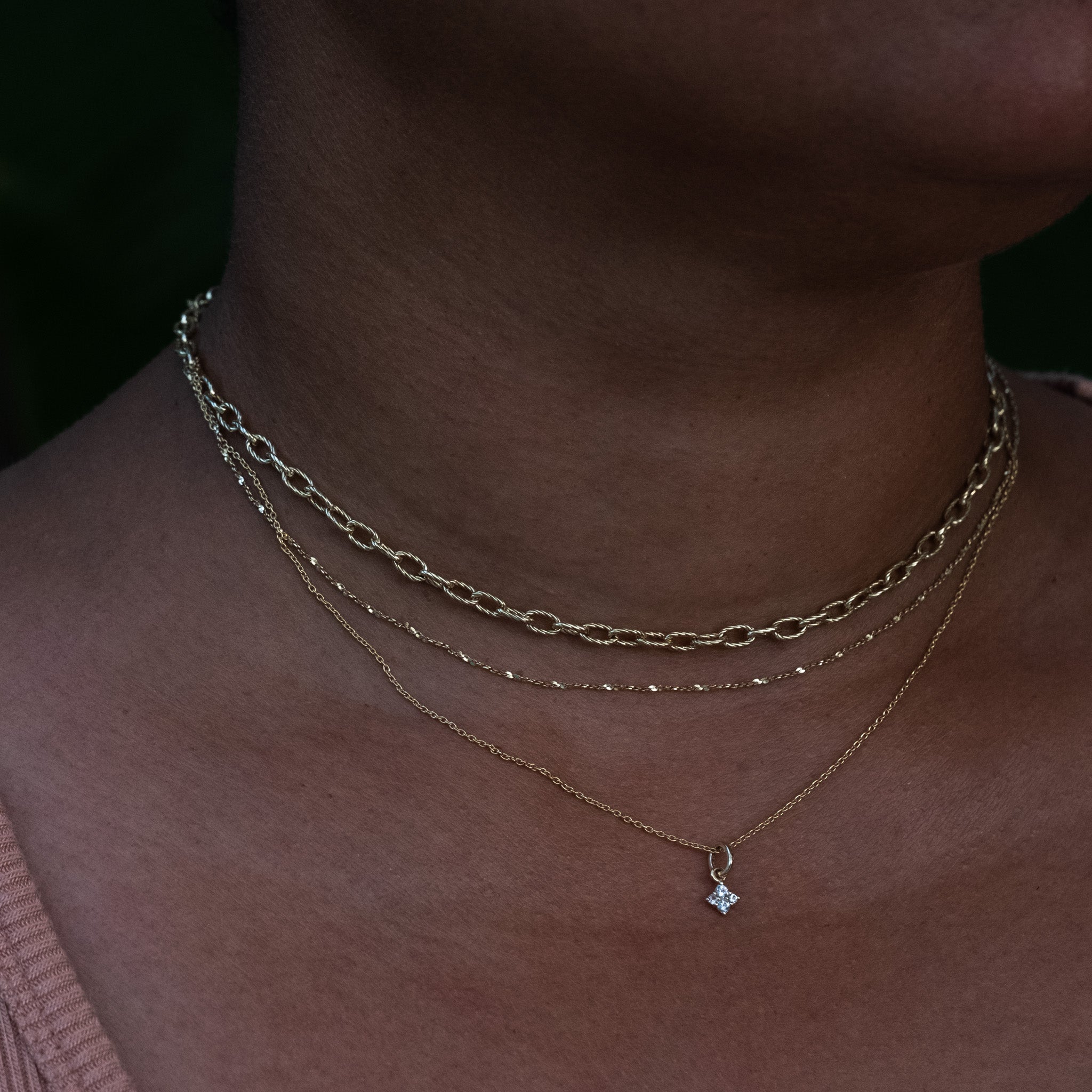 A close up of a person wearing the Aiden Jae Stardust Charm Necklace.