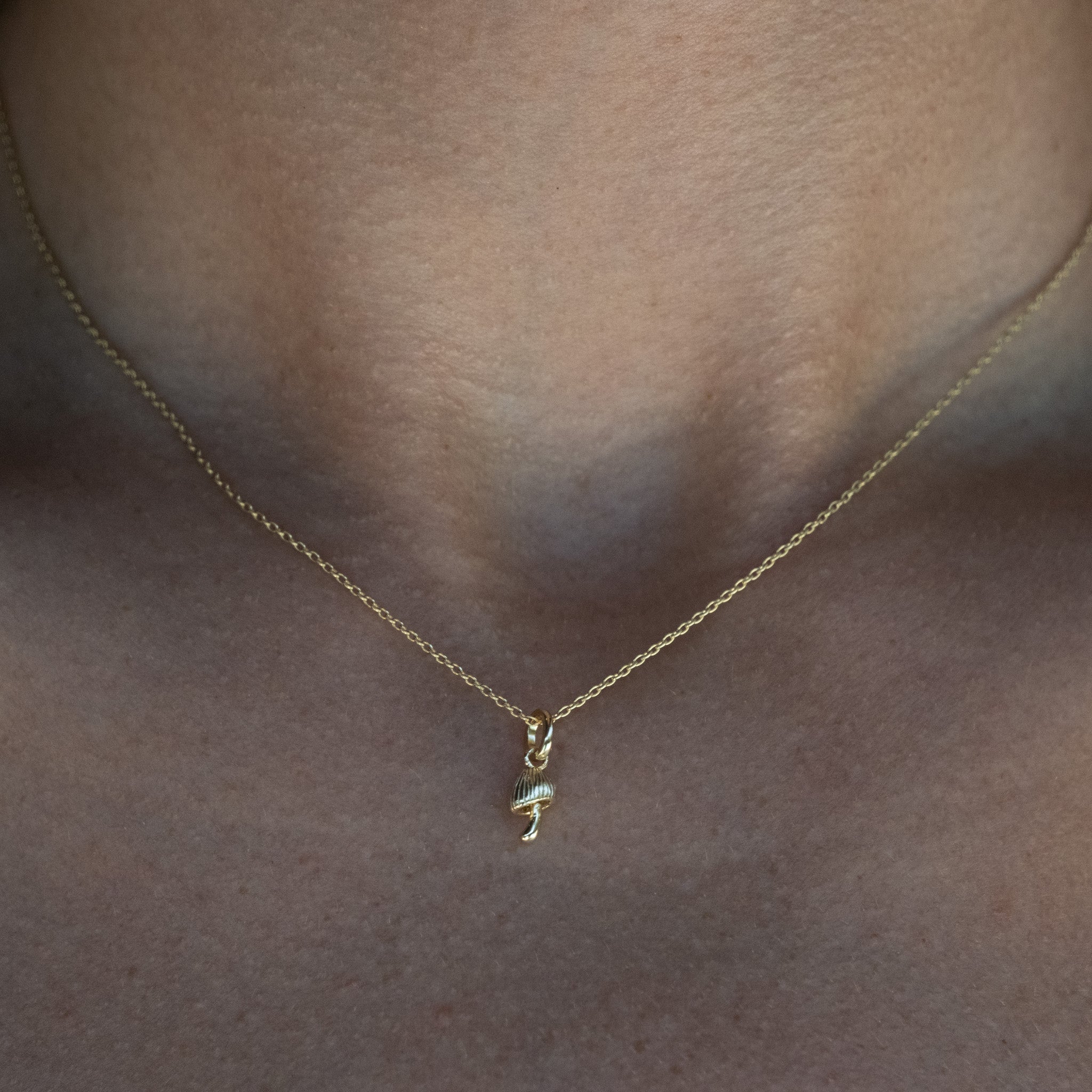 A close up of a person wearing an Aiden Jae Mini Mushroom Charm Necklace.