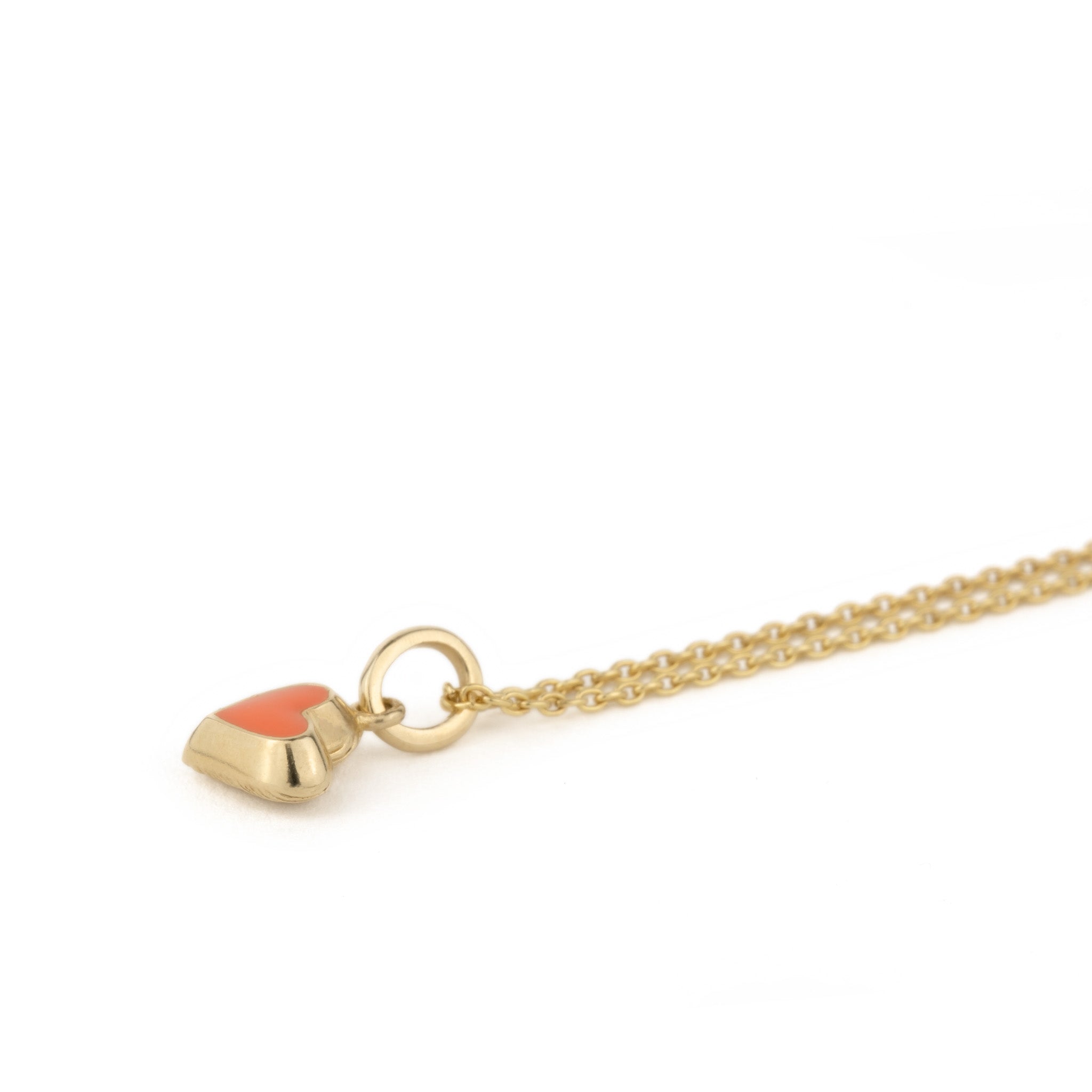 An Aiden Jae Mini Reversible Heart Charm Necklace with an orange stone on it.