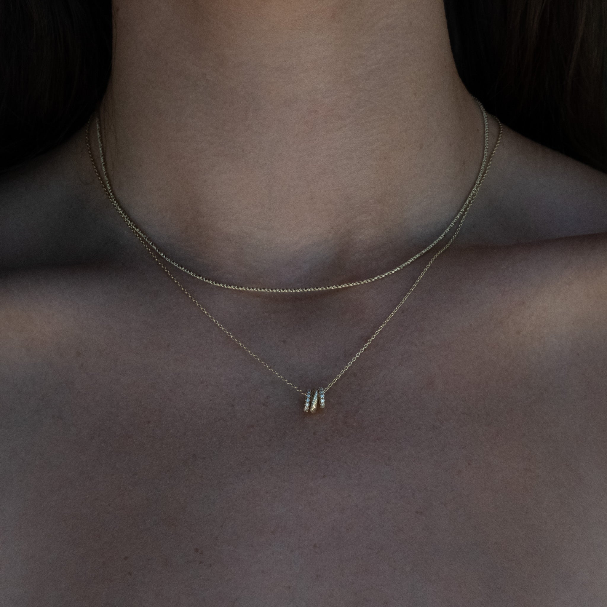 A close up of a woman's chest wearing the Aiden Jae Twilight Link Charm Necklace.