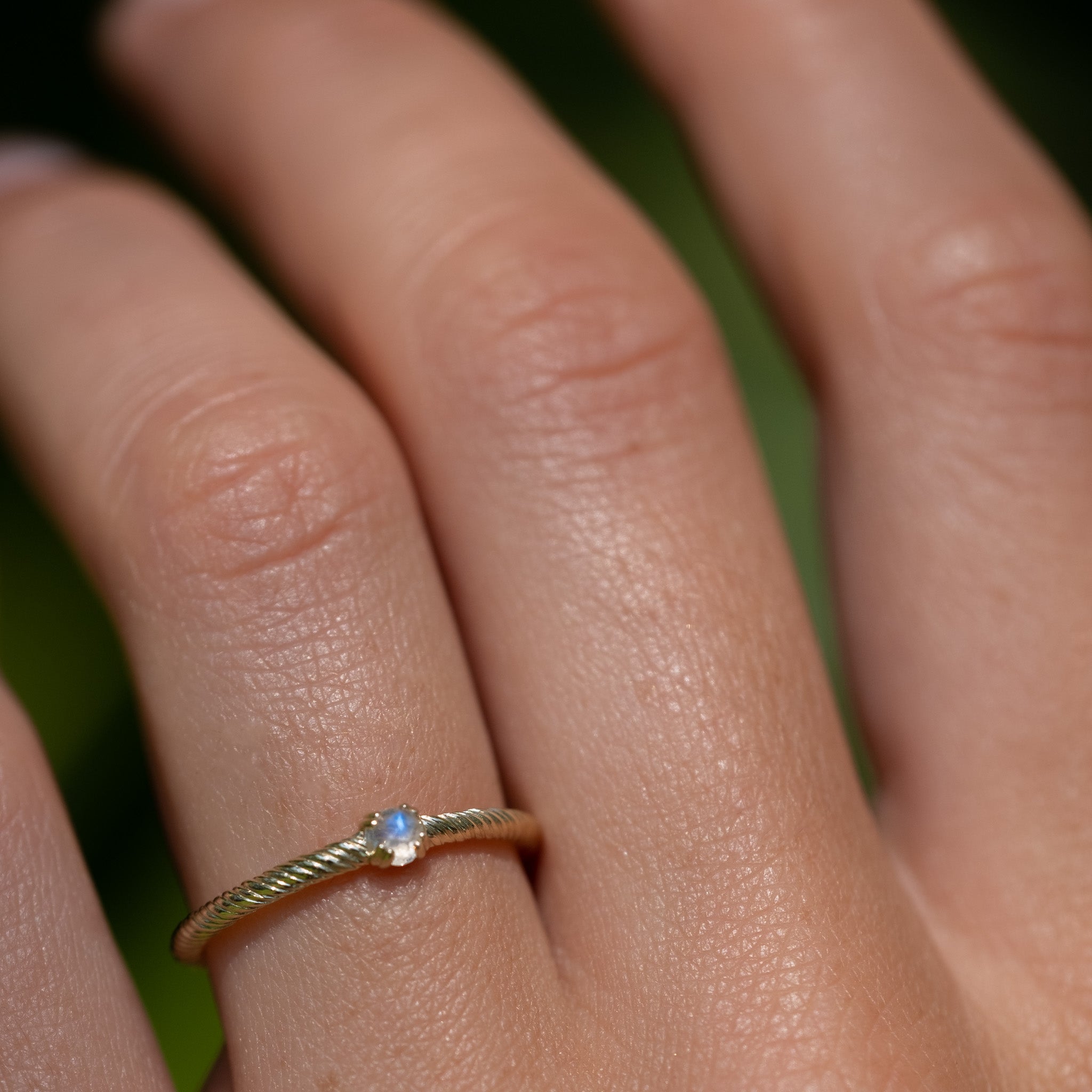 A close up of a person's hand with Aiden Jae's Moonlight Ring on it.