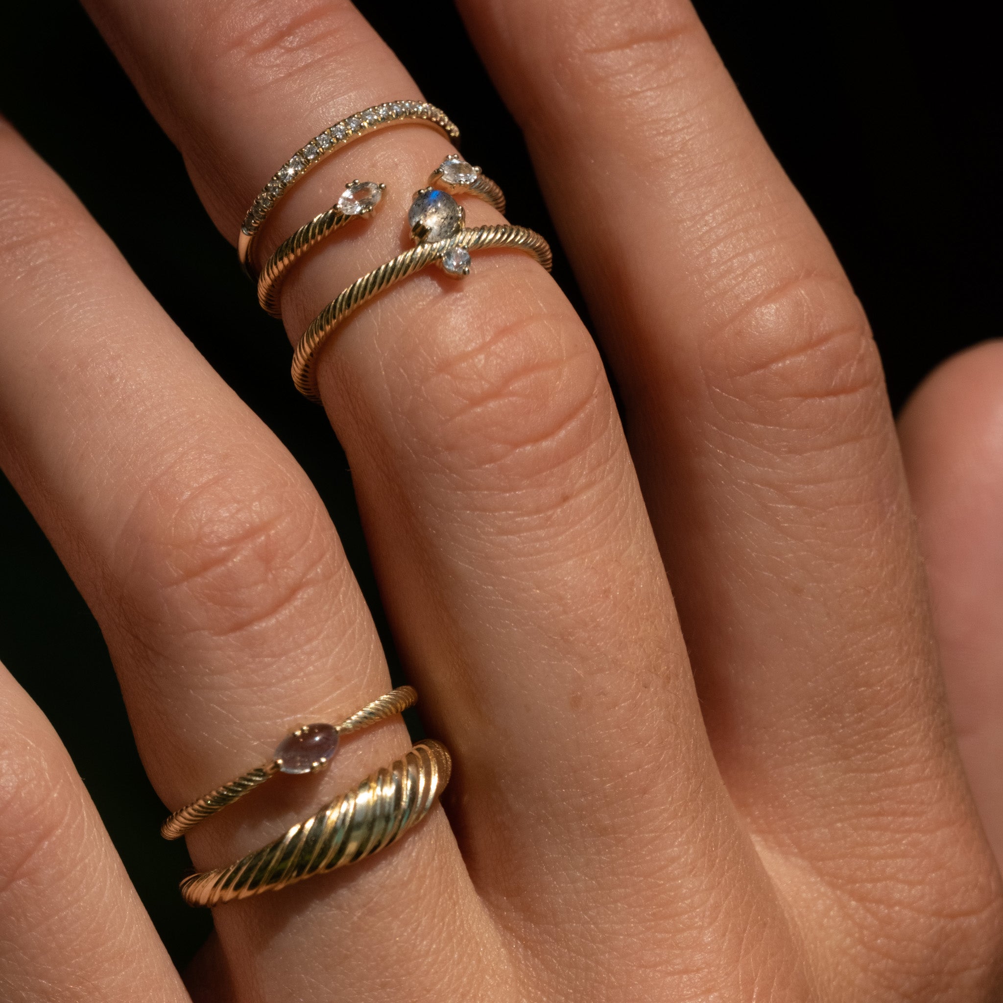 A close up of a person's hand with Aiden Jae's Daybreak Ring on it.