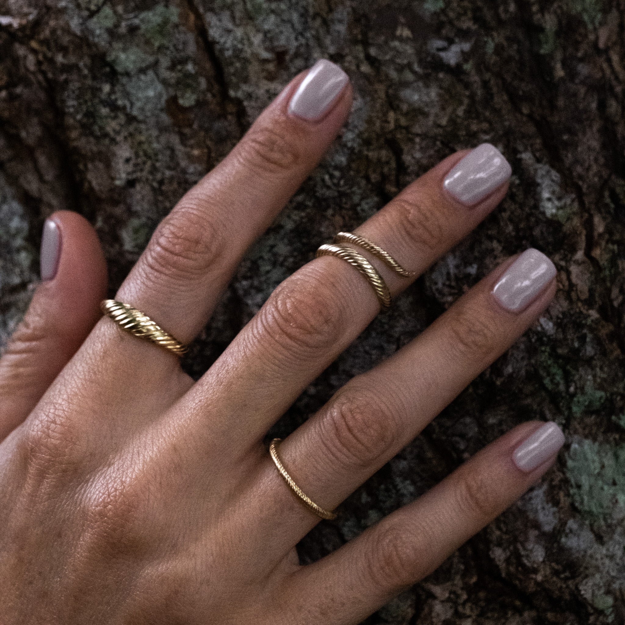 A woman's hand with an Aiden Jae Banyan Thin Band Ring on it.