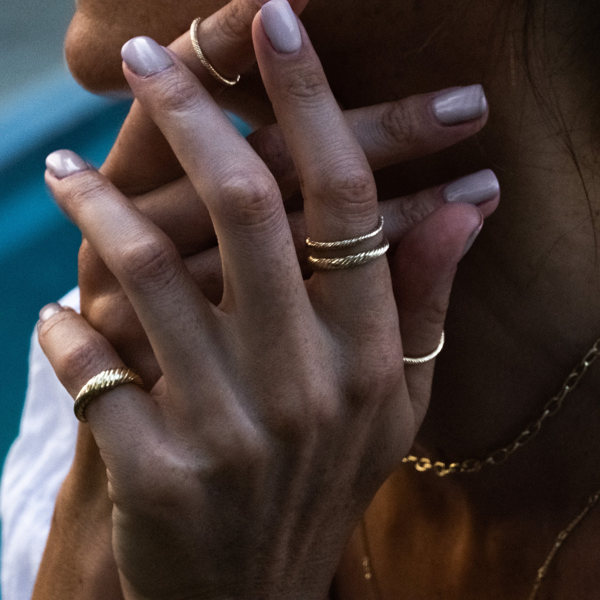 a close up of a person holding an Aiden Jae Banyan Dome Ring to their ear.