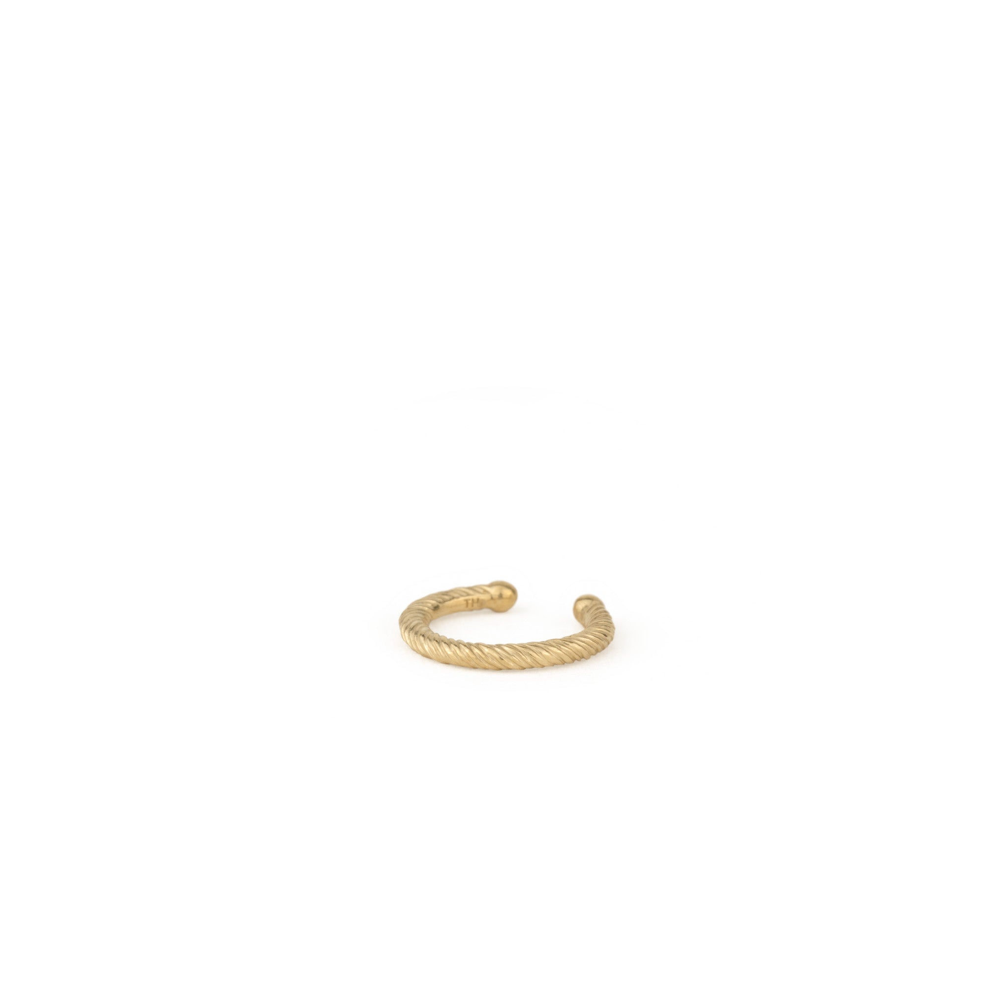 Solid gold ear cuff with twisted texture and minimalist design, angled front view on white background.