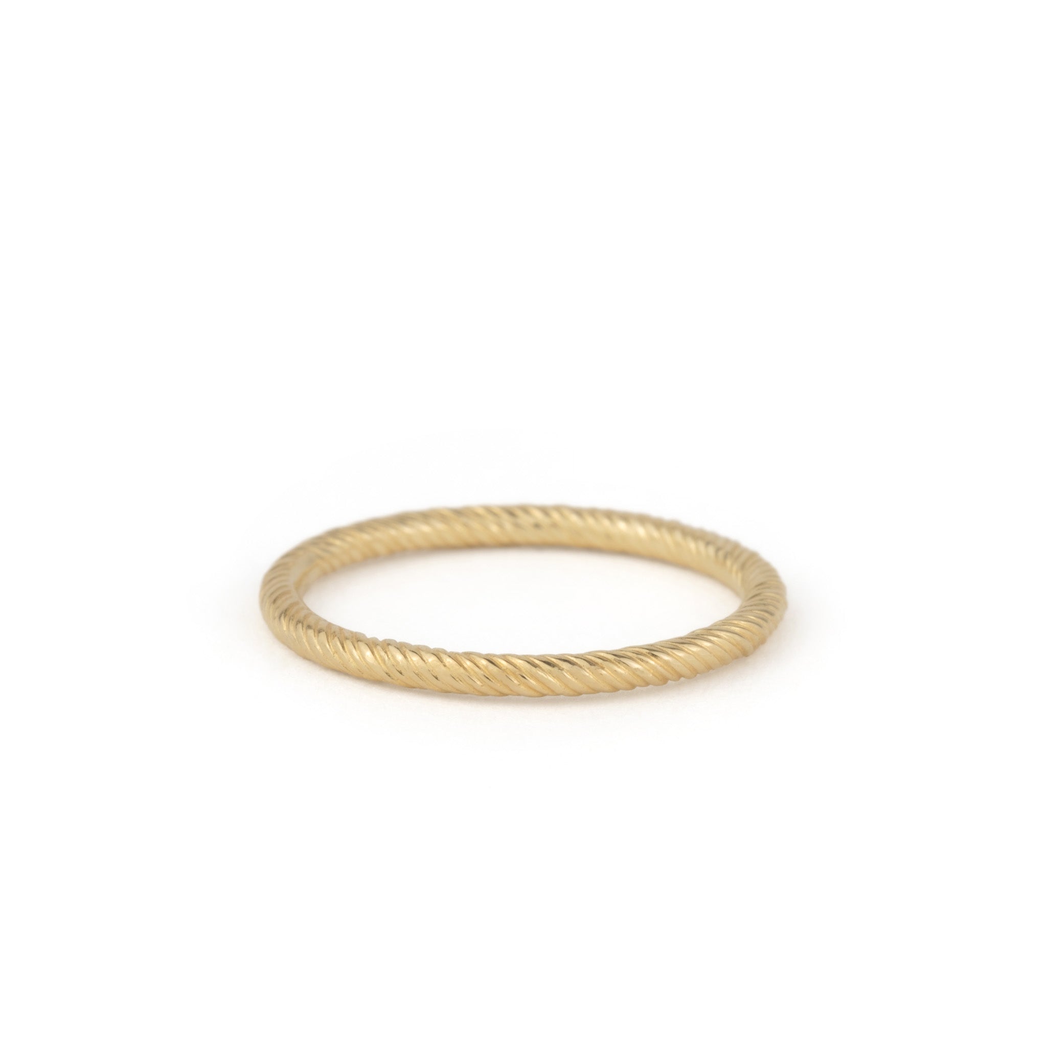 Solid gold stackable thin band ring with twisted texture and minimalist design, displayed on white background.