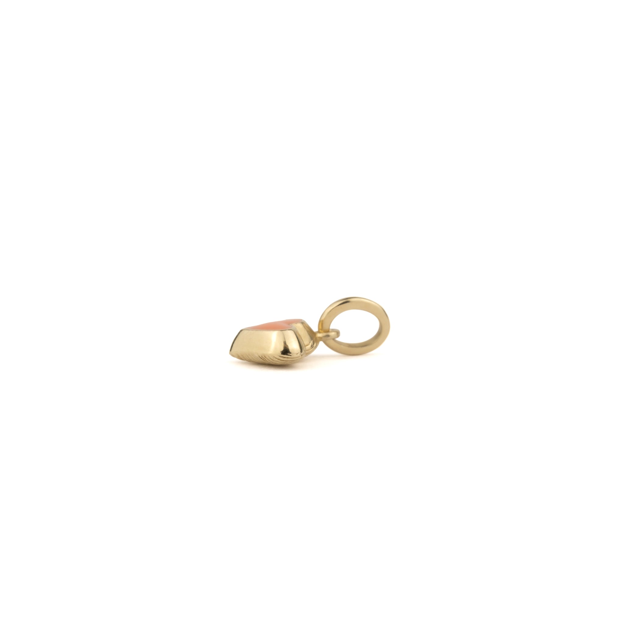 Side view of puffy solid gold tiny heart charm pendant with coral enamel, reversible to texture, shown on white background.