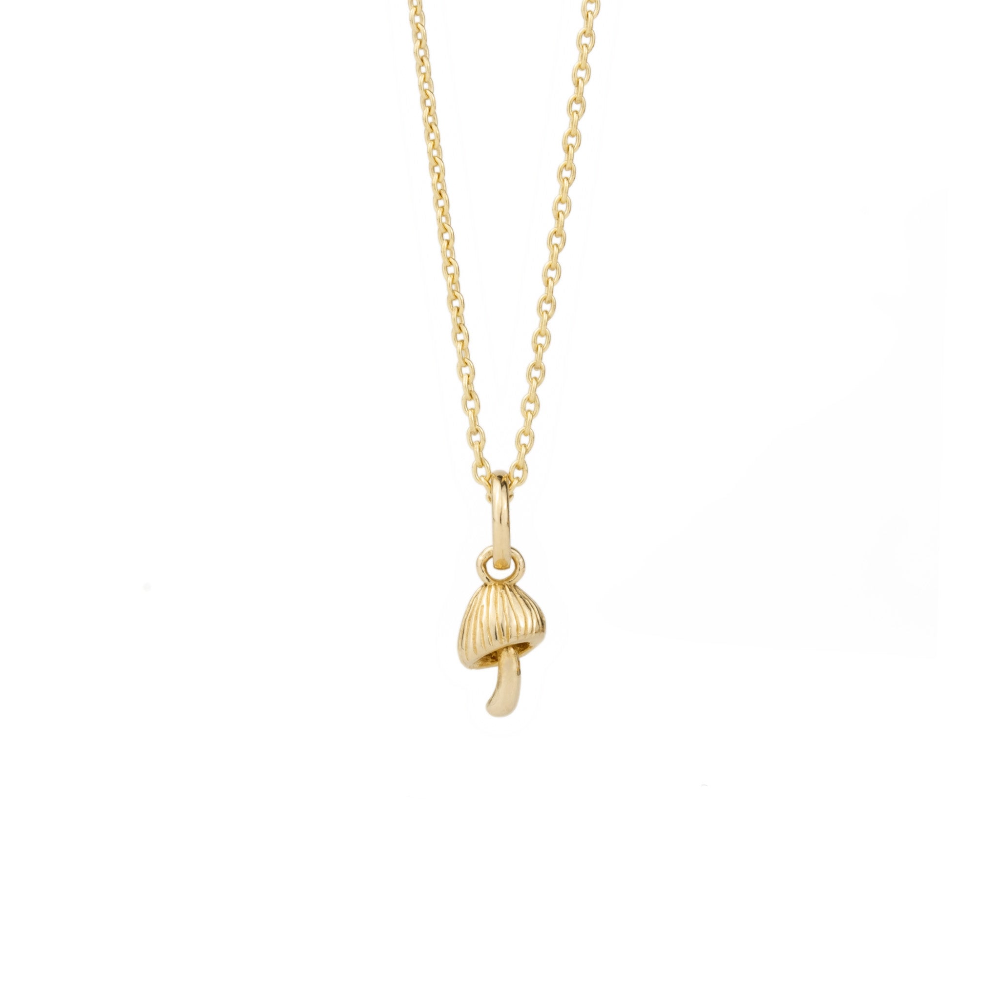 Solid gold tiny mushroom charm pendant, in a minimalist design, hanging on cable chain, displayed on white background.
