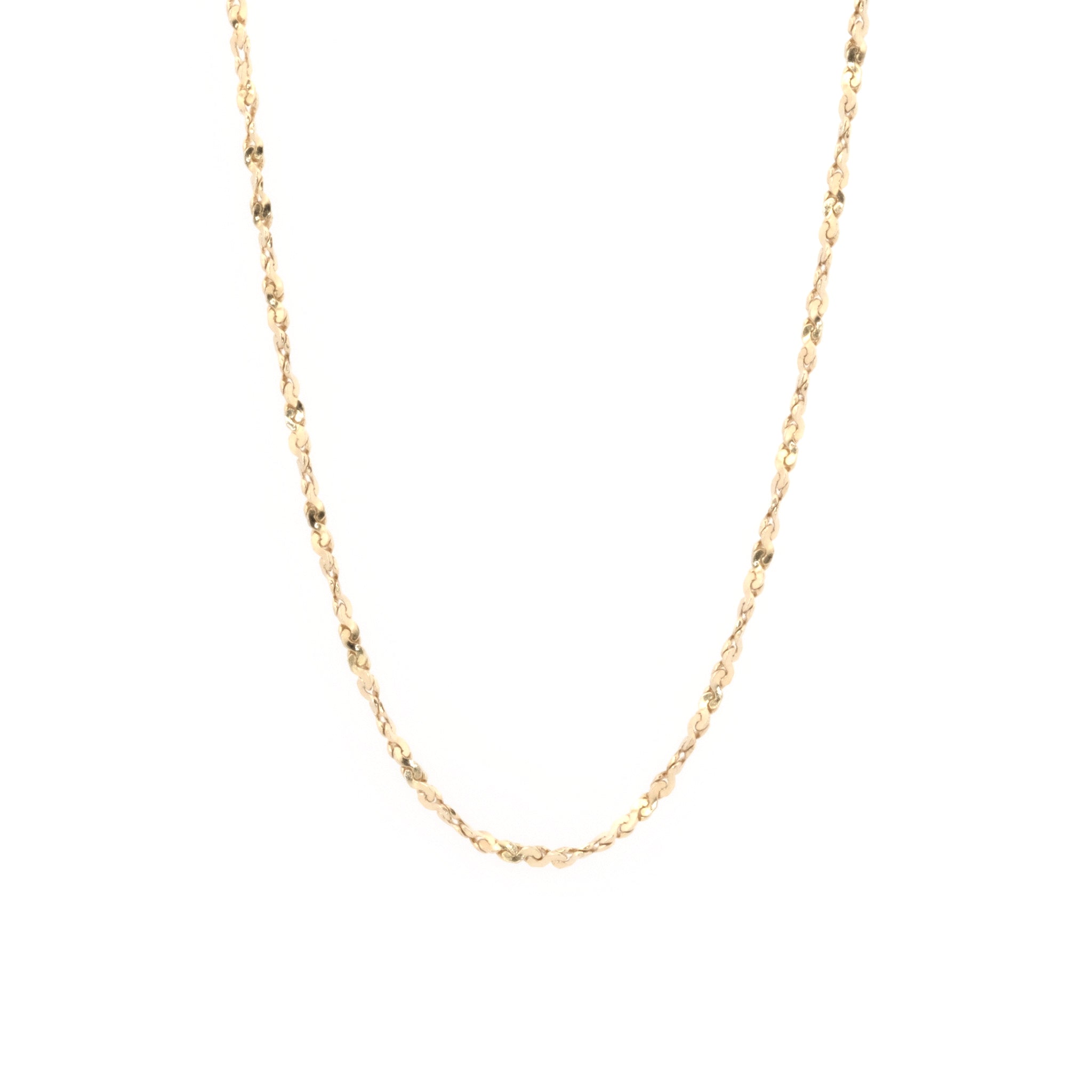 Delicate solid gold twisted serpentine chain necklace with minimalist aesthetic, hanging against white background.